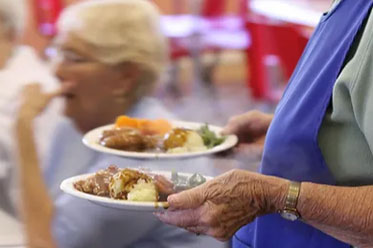 Person serving plates of dinner