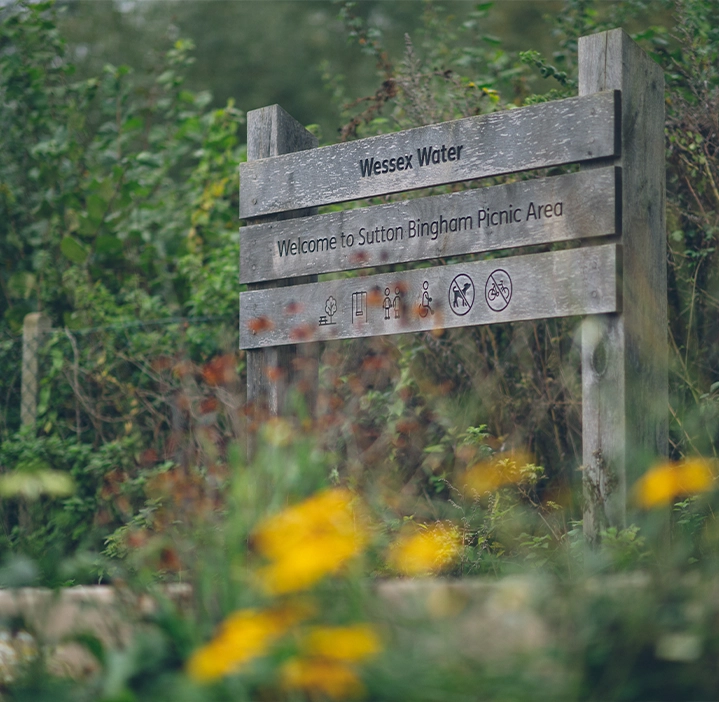 Wooden sign surrounded by flowers marking the Sutton Bingham picnic area